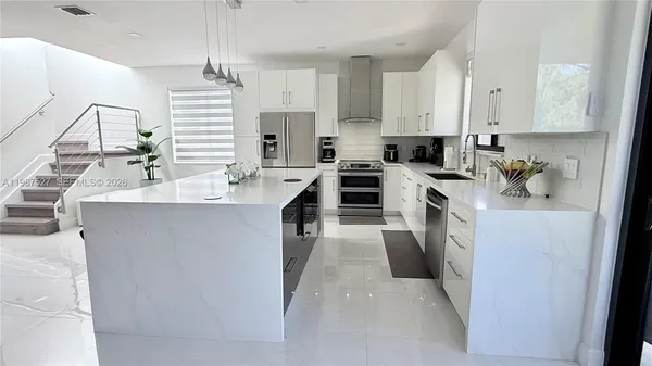 a kitchen with a refrigerator stove and white cabinets