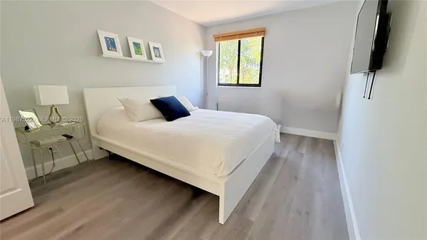 a kitchen with a sink a stove a refrigerator and white cabinets with wooden floor