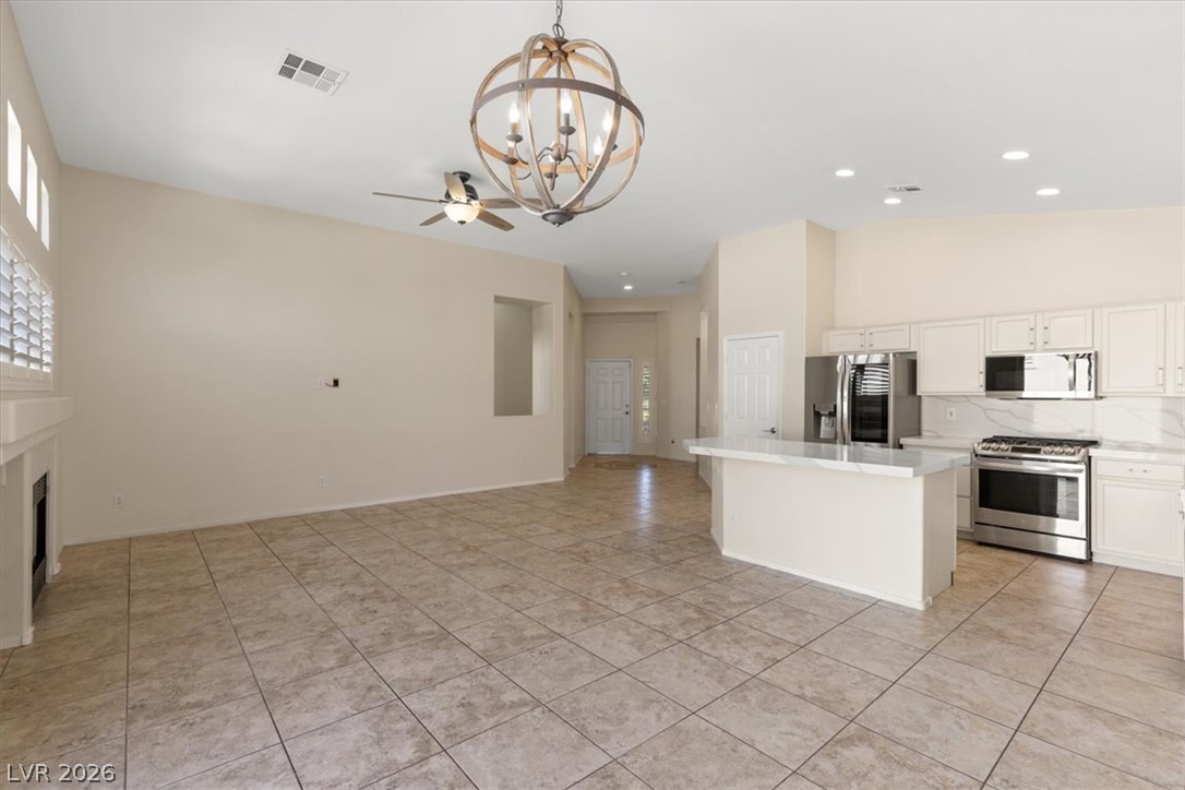 1007 Golden Ridge Court Henderson, NV 89052 - Photo 7 of 27 Tiled flooring and high ceilings define this open-concept layout connecting kitchen and living areas.