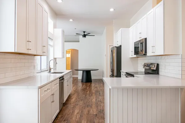 a kitchen with wooden floors and white walls