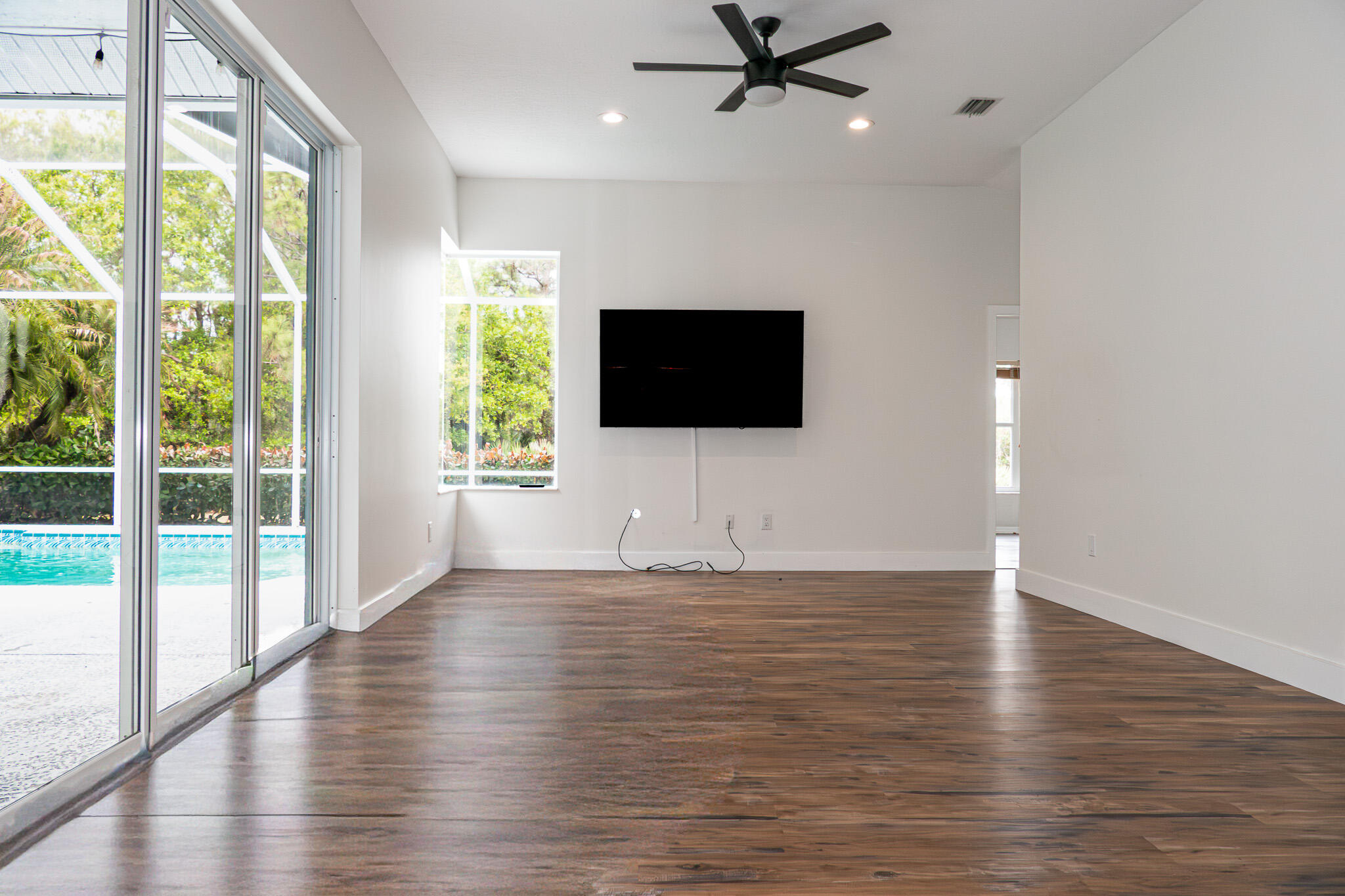 7685 Pleasant Ridge Court Stuart, FL 34997 - Photo 18 of 66 a view of an empty room with wooden floor and a window