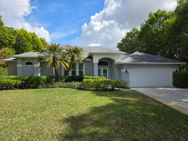 a front view of a house with a garden and yard