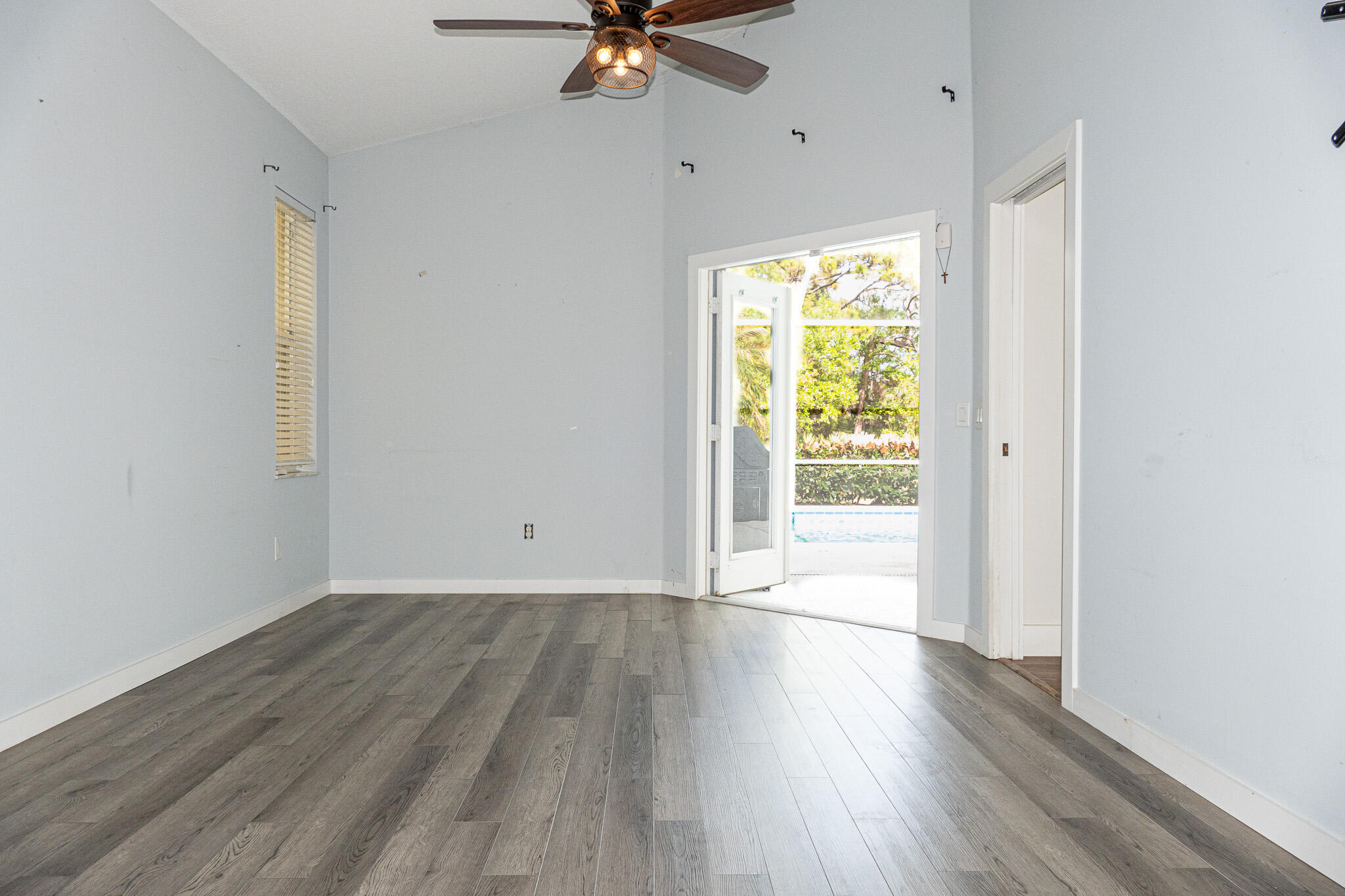 7685 Pleasant Ridge Court Stuart, FL 34997 - Photo 22 of 66 a view of an empty room with wooden floor and a window