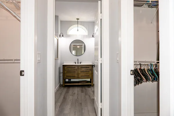 a view of a hallway with wooden floor and closet