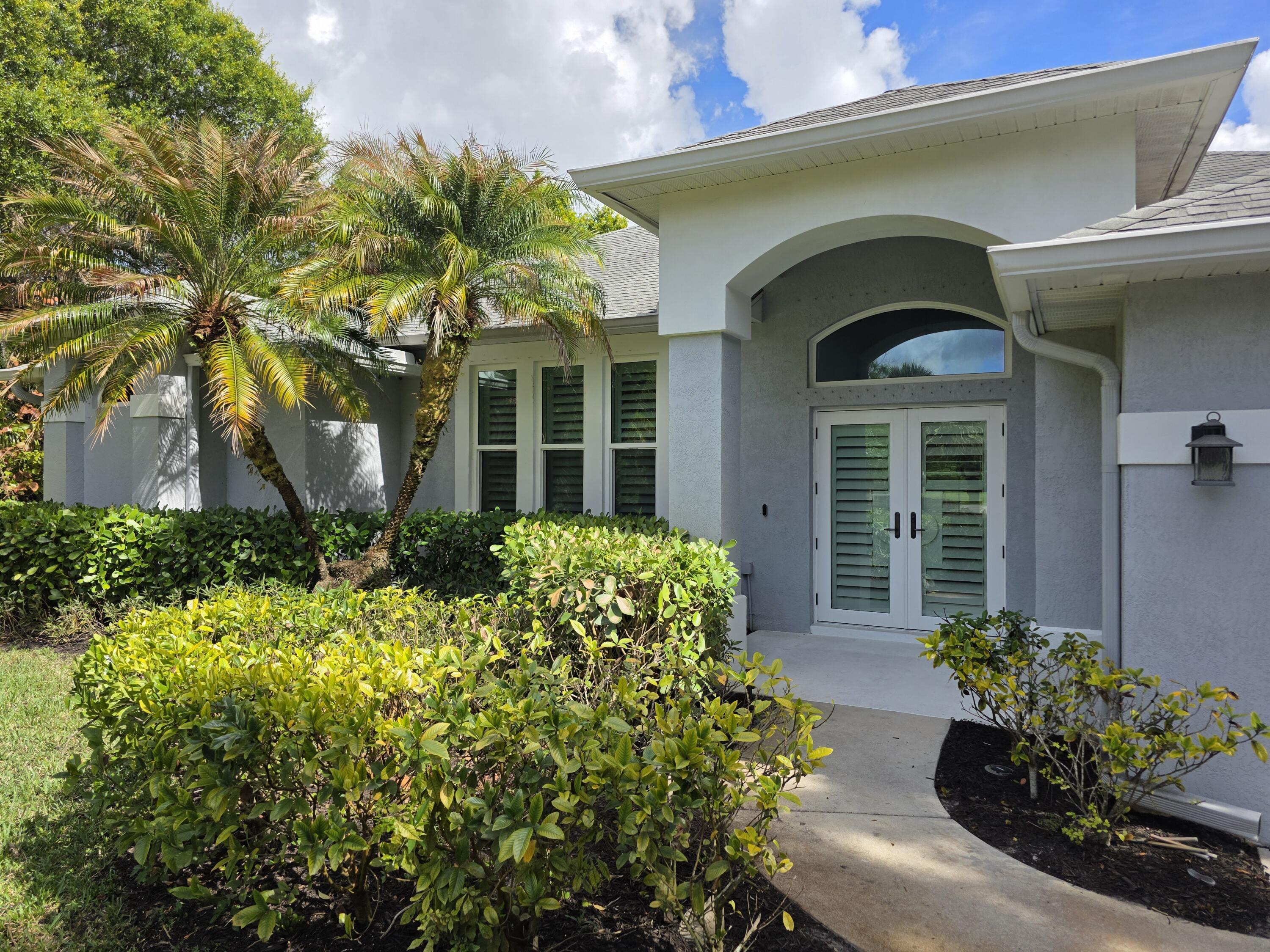7685 Pleasant Ridge Court Stuart, FL 34997 - Photo 3 of 66 a front view of a house with a yard