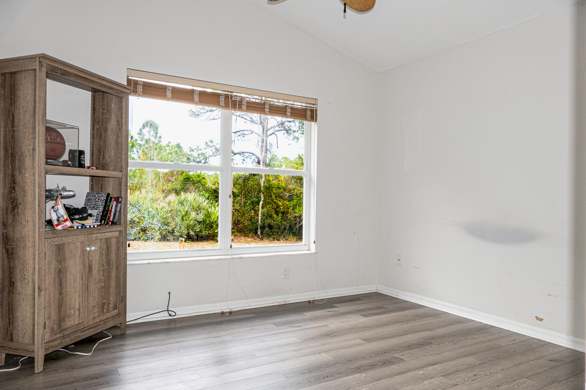 7685 Pleasant Ridge Court Stuart, FL 34997 - Photo 34 of 66 an empty room with wooden floor and a window