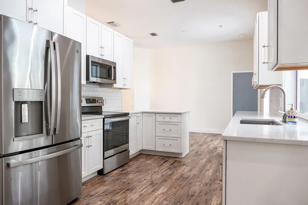 a kitchen with stainless steel appliances granite countertop a sink stove refrigerator and cabinets