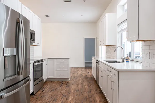 a kitchen with stainless steel appliances granite countertop a sink stove and refrigerator