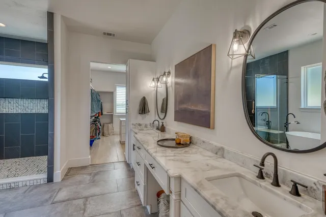 a bathroom with a granite countertop sink a mirror and shower