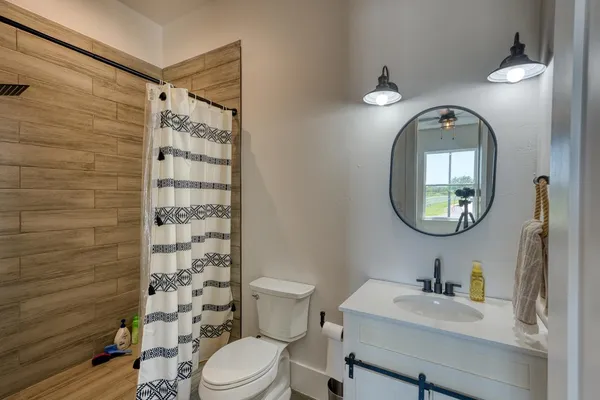 a bathroom with a toilet a sink and a mirror