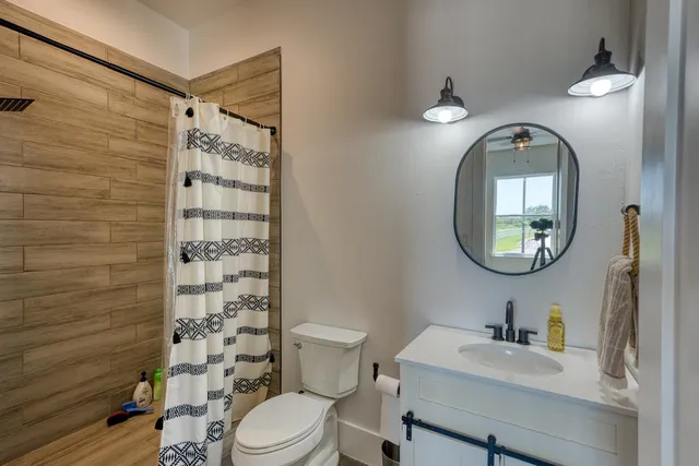 a bathroom with a toilet a sink and a mirror