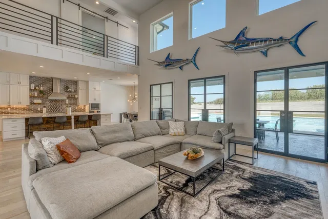 a living room with furniture wooden floor and a large window