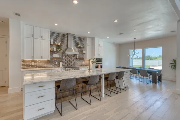 a large kitchen with lots of counter space a dining table chairs and granite counter tops
