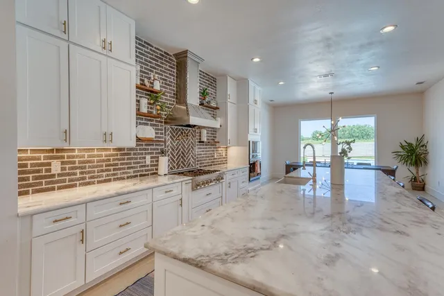 a kitchen with stainless steel appliances granite countertop a stove and cabinets