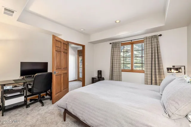 a bedroom with a bed a chair and a large window