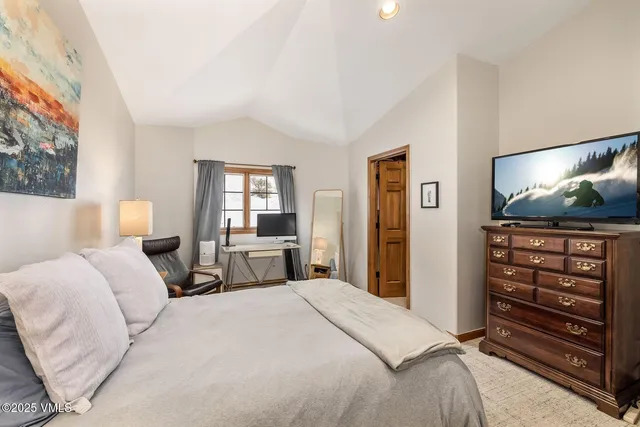 a bedroom with a bed and a flat screen tv