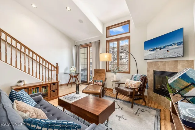 a living room with furniture a fireplace and a floor to ceiling window
