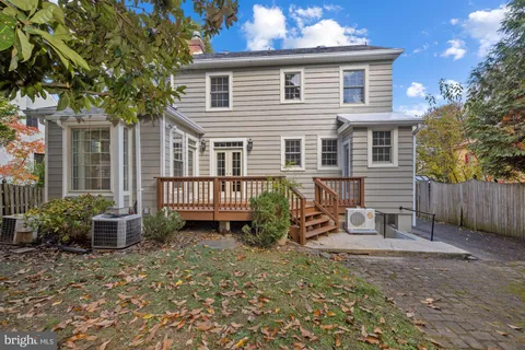 a view of a house with a small yard and large tree