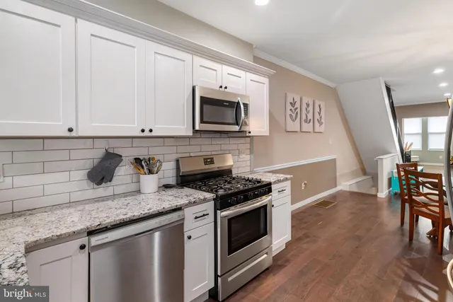 a kitchen with granite countertop cabinets stainless steel appliances and wooden floor