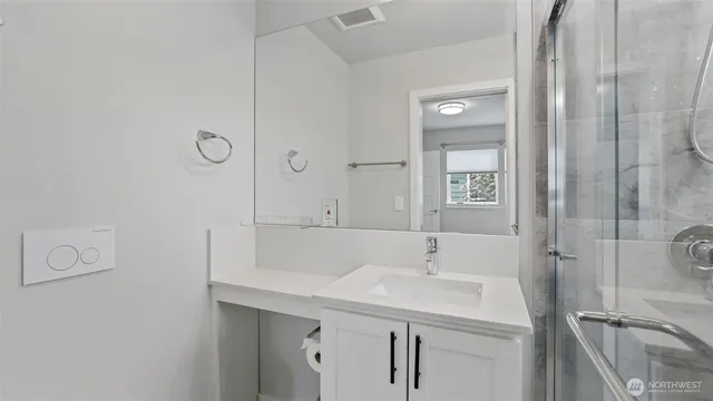 a bathroom with a sink a toilet and shower