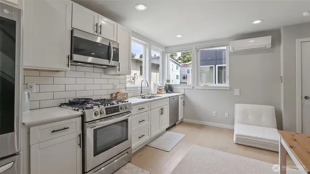 a kitchen with stainless steel appliances a stove microwave and sink