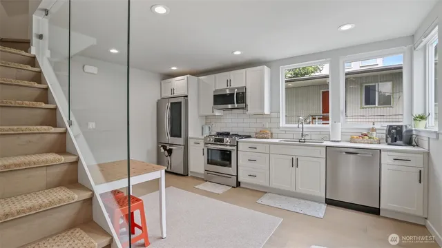 a kitchen with white cabinets and stainless steel appliances