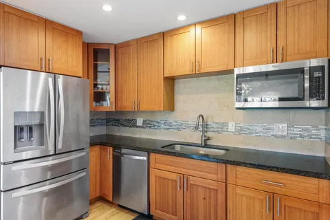 a kitchen with stainless steel appliances wooden cabinets and a sink