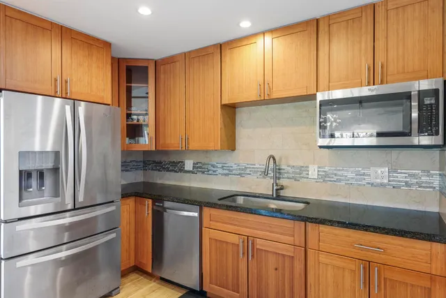 a kitchen with stainless steel appliances wooden cabinets and a sink