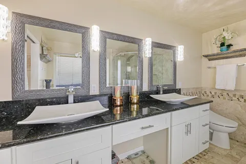 a spacious bathroom with a granite countertop sink and a mirror