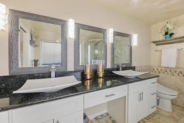 a spacious bathroom with a granite countertop sink and a mirror