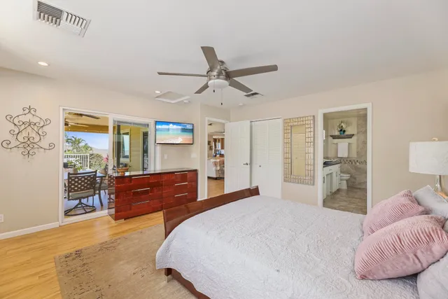 a bedroom with a bed dresser and wooden floor