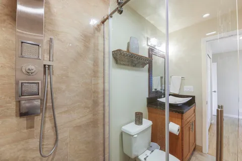 a bathroom with a granite countertop sink toilet and shower