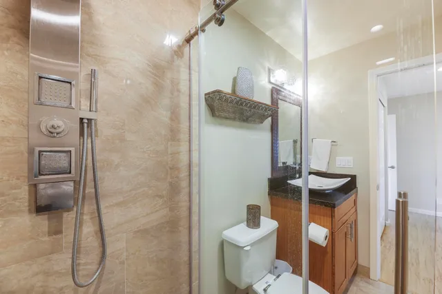 a bathroom with a granite countertop sink toilet and shower