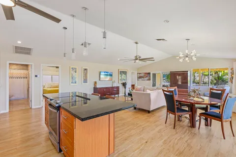 a kitchen with stainless steel appliances granite countertop a kitchen island a stove a table and chairs