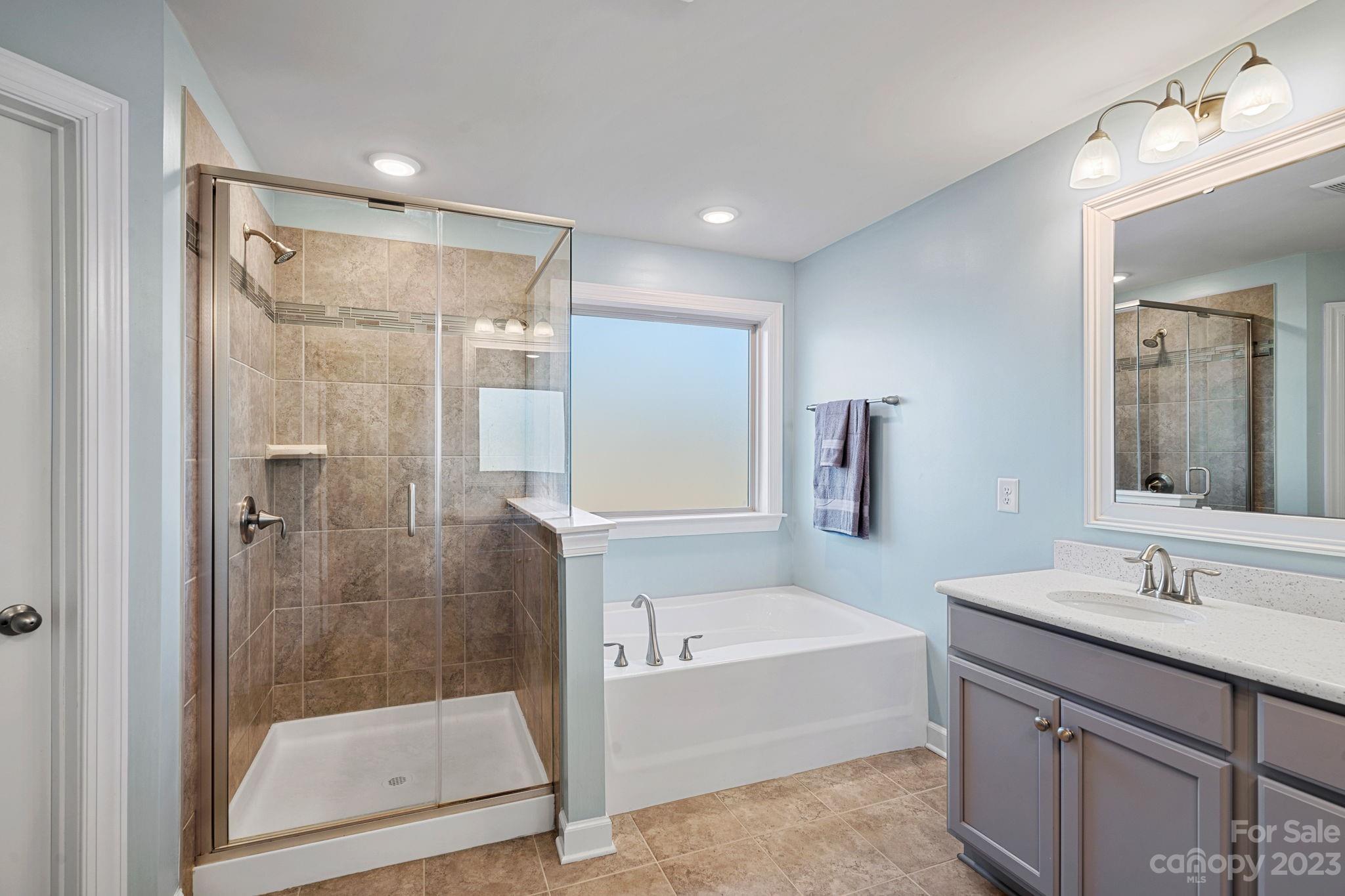 17423 Shearer Road Davidson, NC 28036 - Photo 33 of 48 a bathroom with a bathtub shower sink vanity and mirror