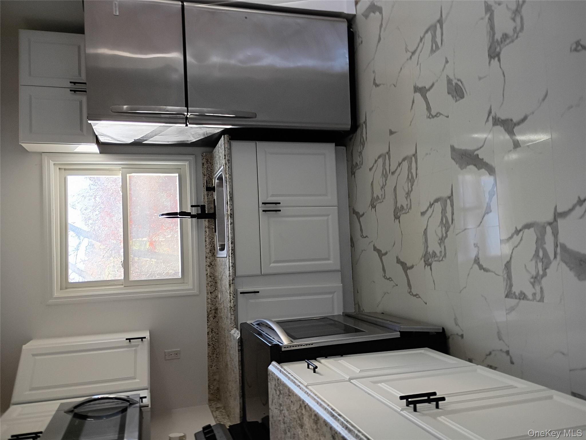 67 Albany Avenue, Unit A&B Flanders, NY 11901 - Photo 12 of 24 Kitchen featuring stove, freestanding refrigerator, light marble finish flooring, white cabinets, and light stone counters
