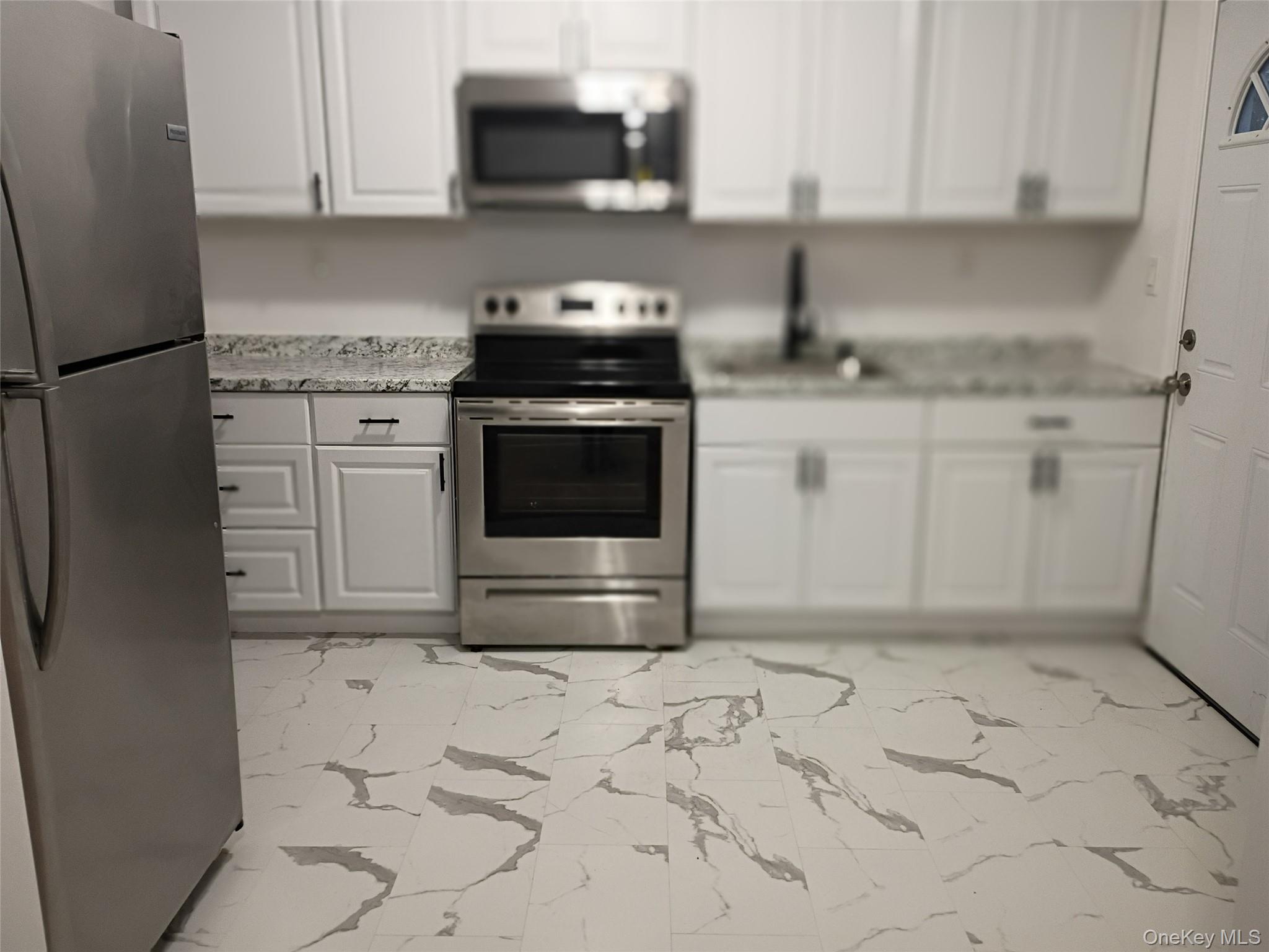 67 Albany Avenue, Unit A&B Flanders, NY 11901 - Photo 17 of 24 1st floor unit kitchen is updated with SS appliances and rear door to yard