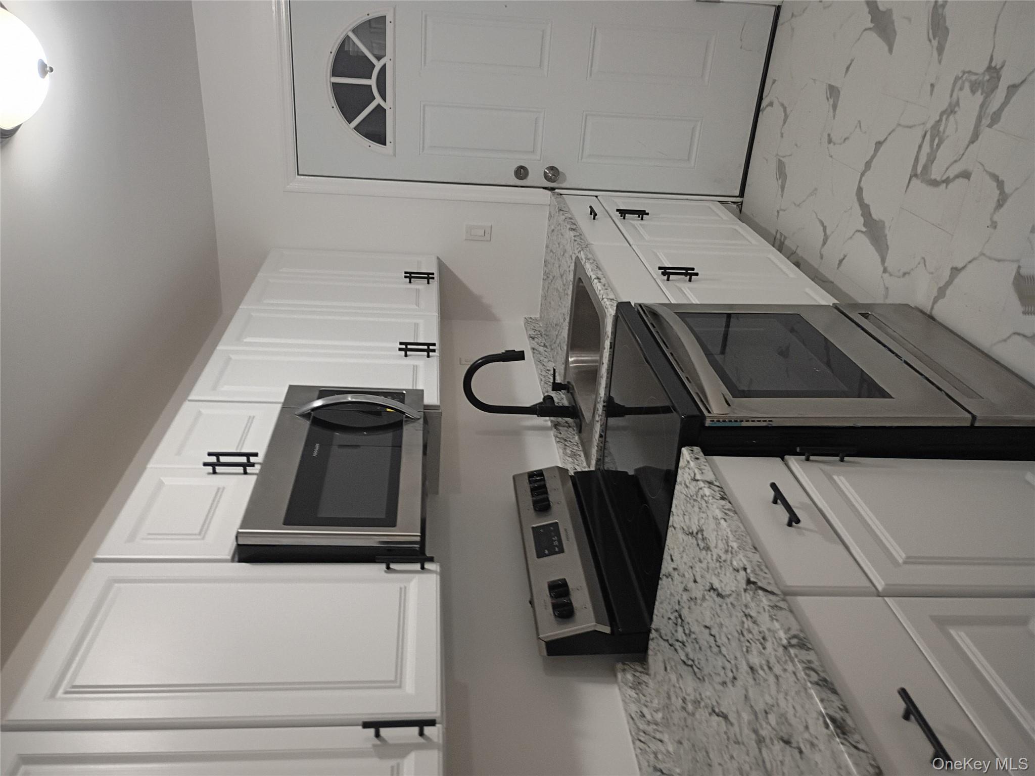 67 Albany Avenue, Unit A&B Flanders, NY 11901 - Photo 4 of 24 Kitchen featuring stainless steel stove, light marble finish flooring, white cabinets, and light stone countertops