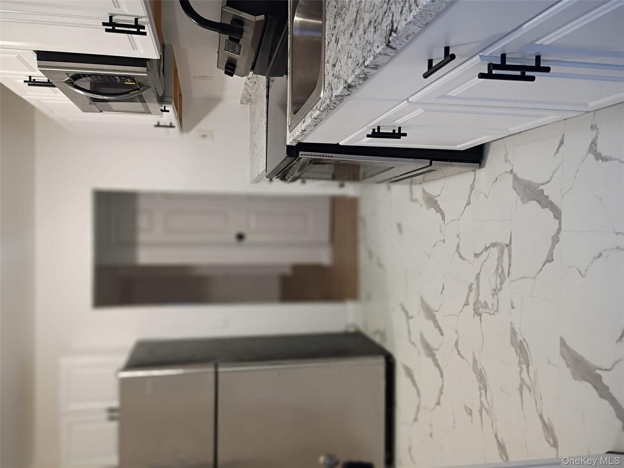 67 Albany Avenue, Unit A&B Flanders, NY 11901 - Photo 6 of 24 Kitchen with stainless steel appliances, white cabinets, light countertops, and light marble finish floors