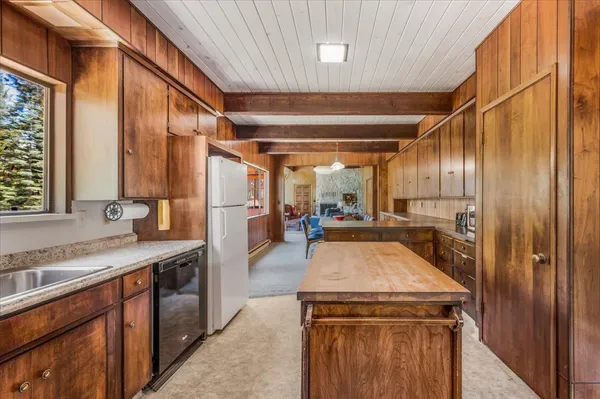 a spacious bedroom with a bed and a dresser next to a window