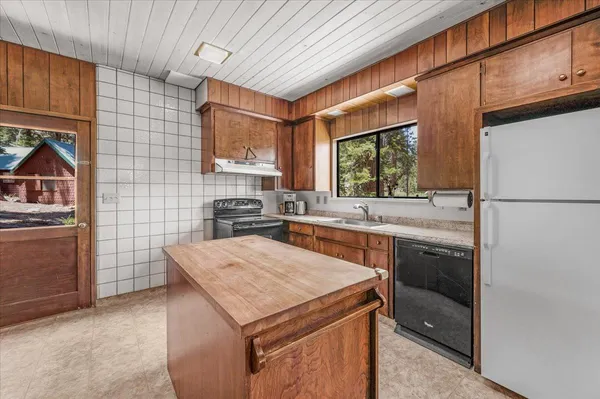 a spacious bedroom with a bed a table and large windows