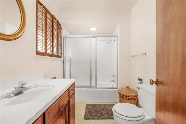 a bedroom with a bed a painting and a window