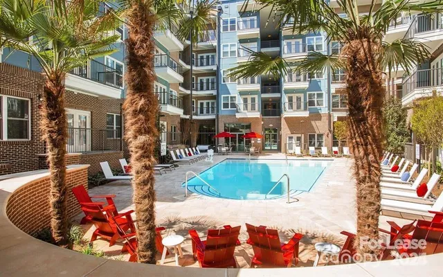 a view of tall buildings with cars parked on road