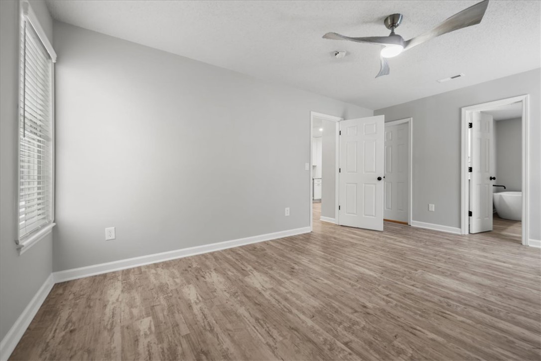212 Blue Ridge Drive Clemson, SC 29631 - Photo 15 of 33 A generously proportioned bedroom features warm wood flooring and an integrated ceiling fan for comfort.