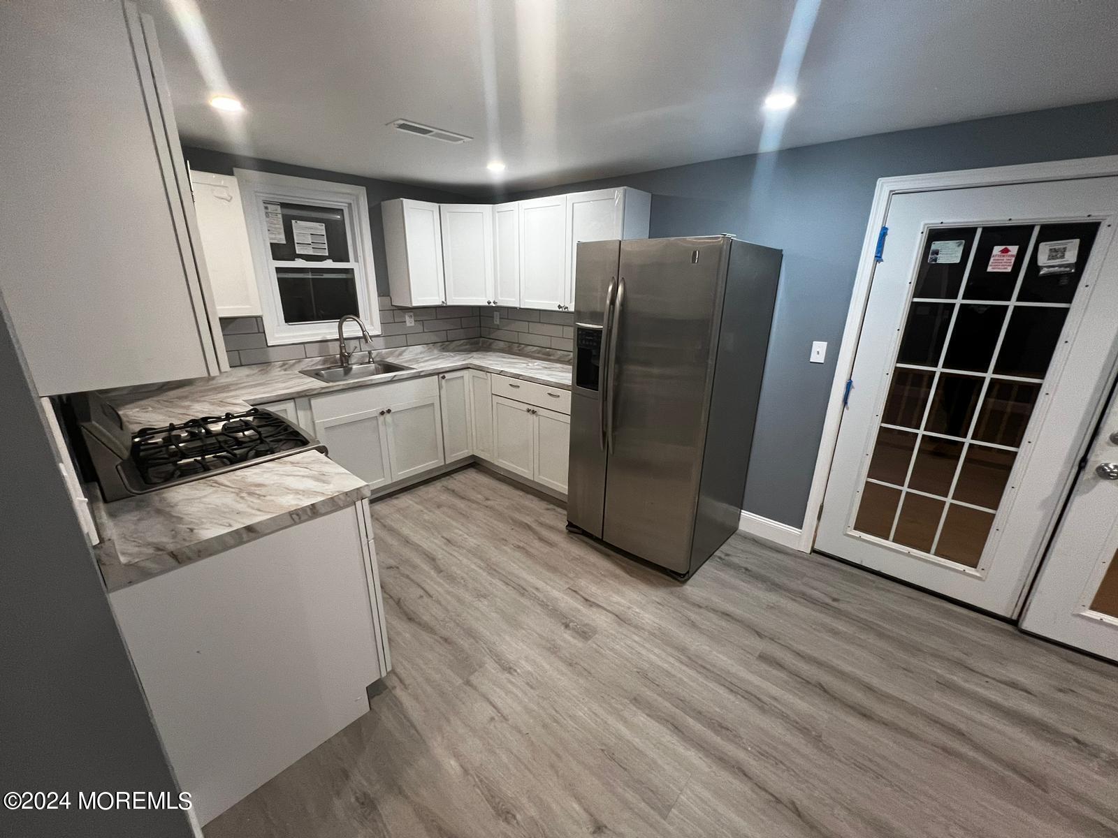 a kitchen with stainless steel appliances a refrigerator and wooden cabinets