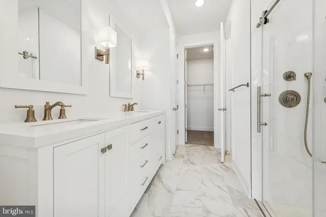 a bathroom with a double vanity sink mirror and shower
