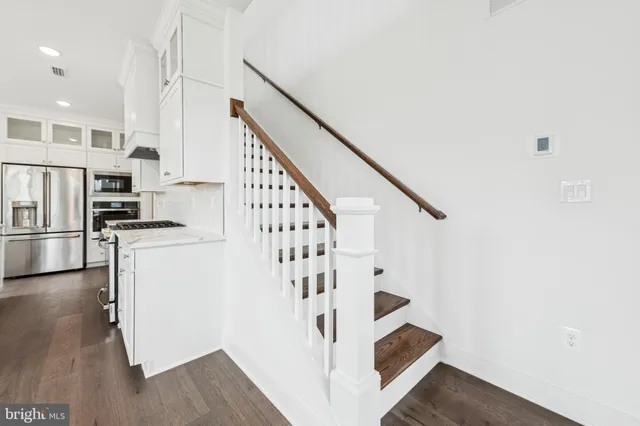 a view of entryway and kitchen with wooden floor