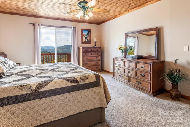 a spacious bedroom with a bed a dresser next to a window