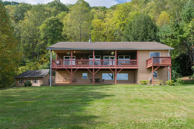 a view of a house with a big yard and large trees