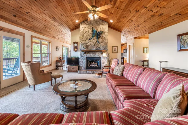 a living room with furniture a fireplace and a chandelier